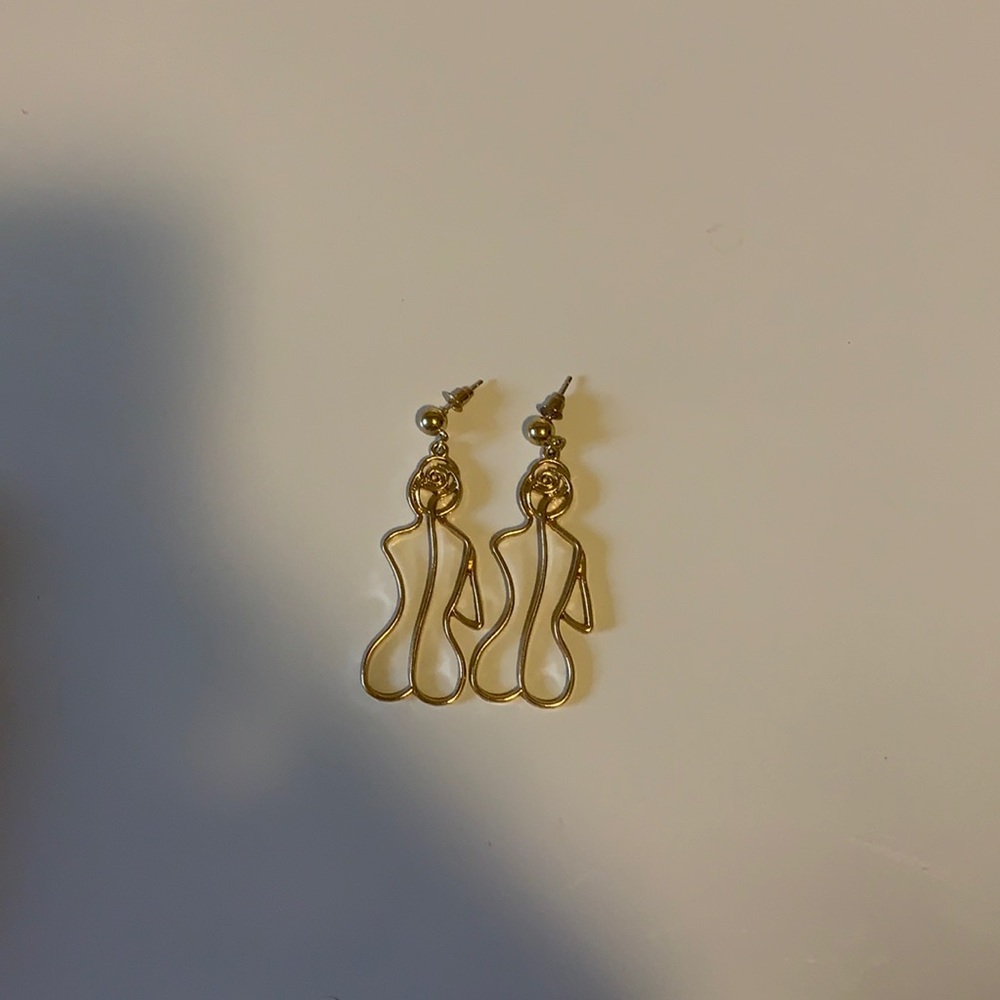 Gold statement earrings woman’s outline